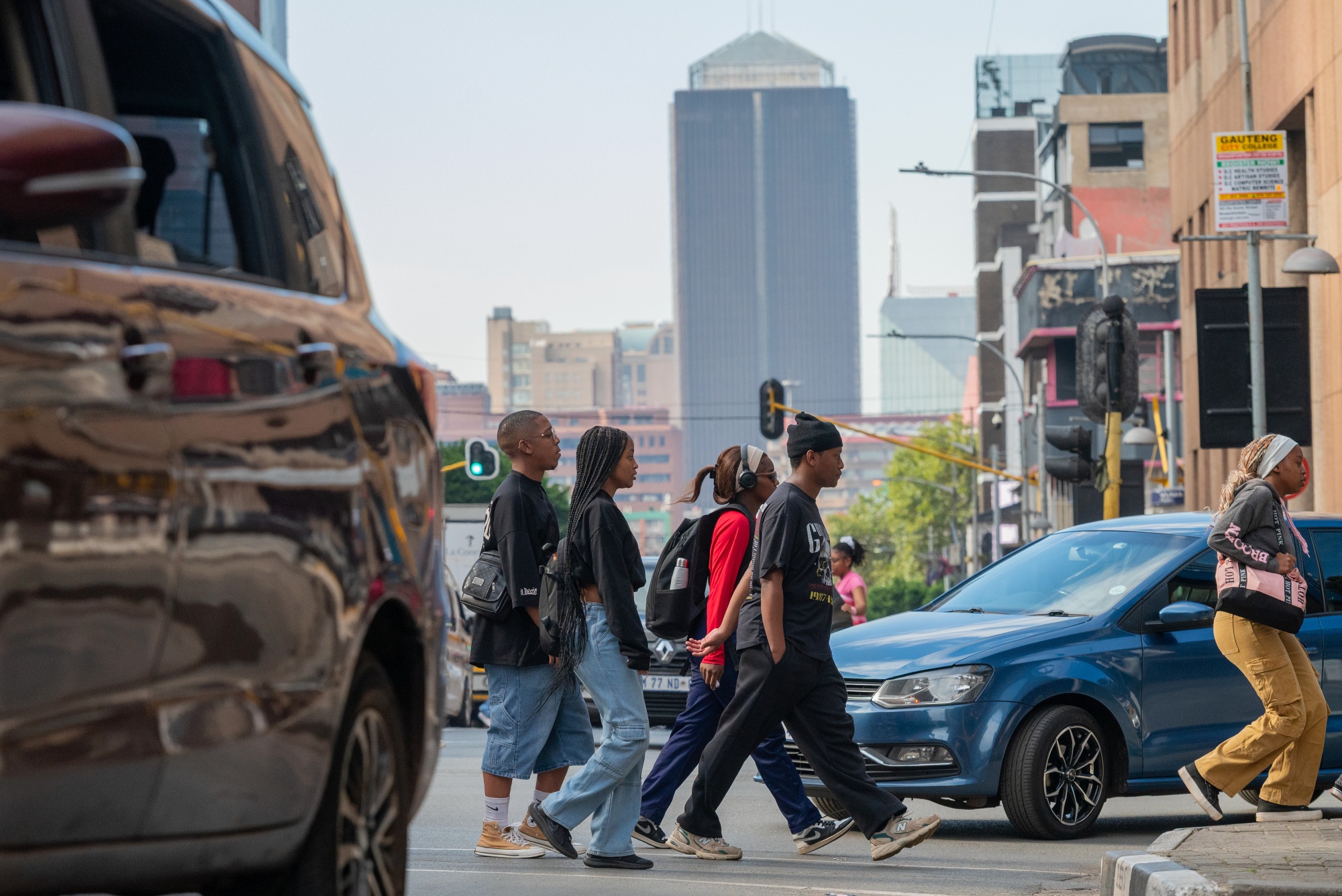 Pedestrians cross a street in the central business district in Johannesburg. Photographer: Leon Sadiki/Bloomberg
