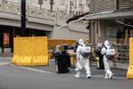 Disinfectant workers walk along a road during a lockdown in Shanghai.