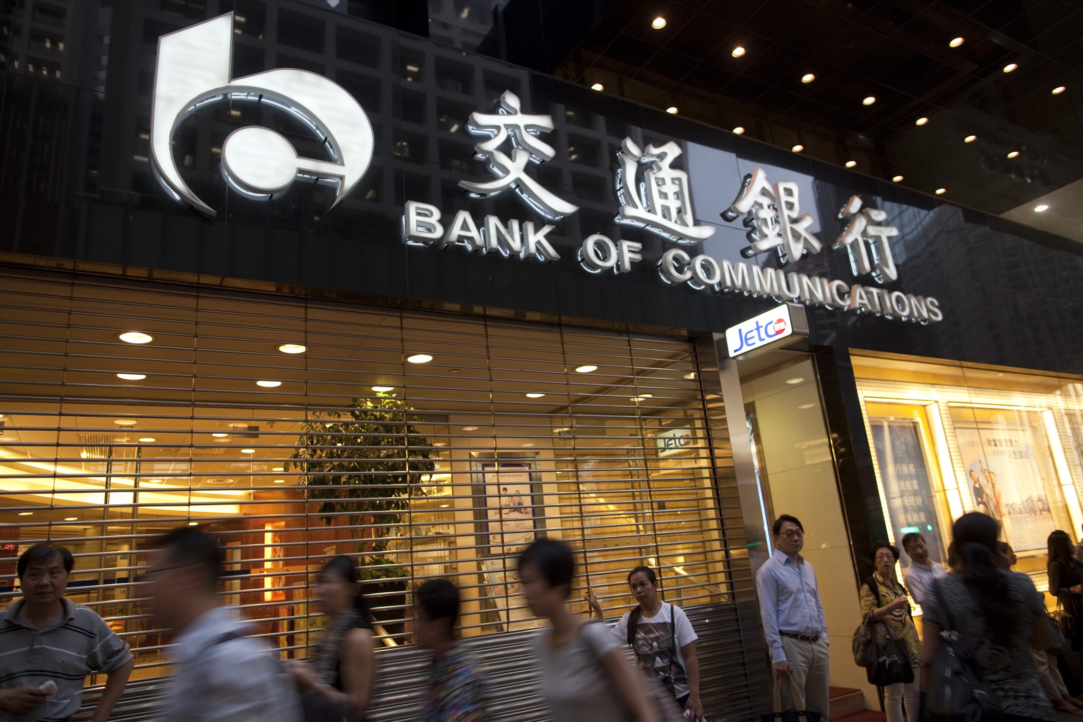 Pedestrians walk past a Bank of Communications Co. branch in Hong Kong, China, on Monday, Aug. 27, 2012.