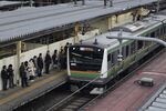 Passengers wait on the platform as an East Japan Railway Co. (JR East) train approaches Shinjuku Station in Tokyo.