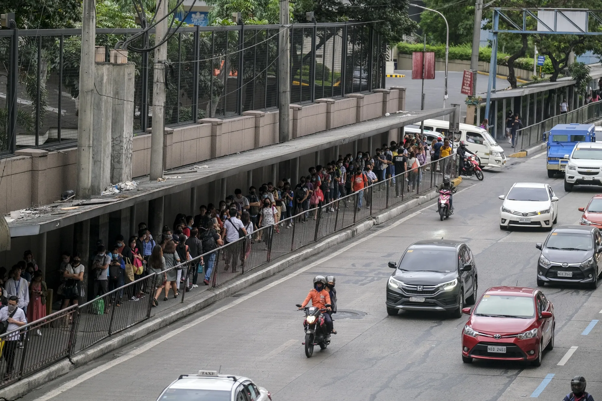 Commuters stand in line to ride the Mass Rapid Transit (MRT) train ahead of a curfew, imposed due to the coronavirus, in Mandaluyong City, Metro Manila on March 16.