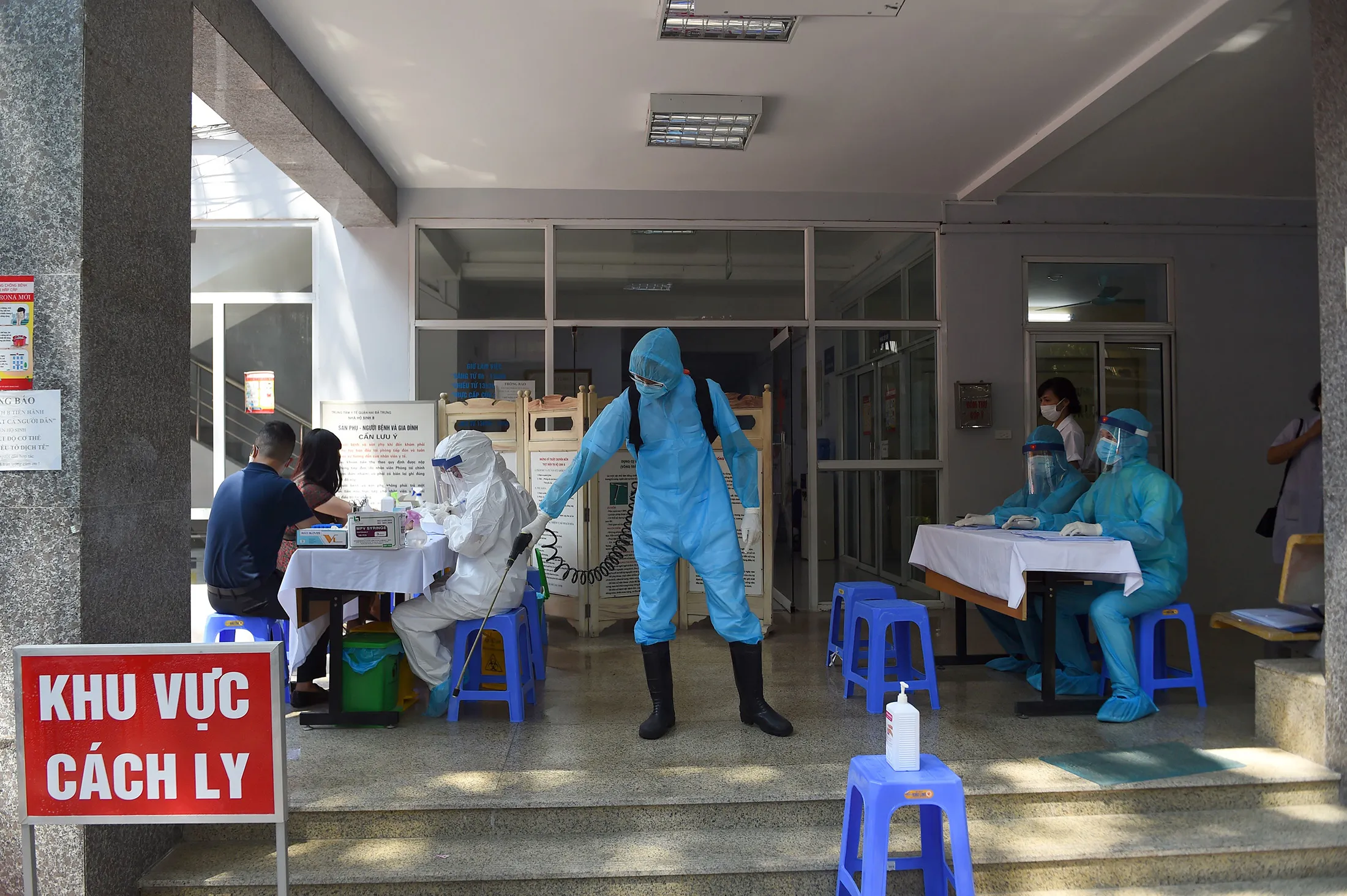 Health workers take blood samples from residents at a makeshift rapid testing centre in Hanoi on July 30.