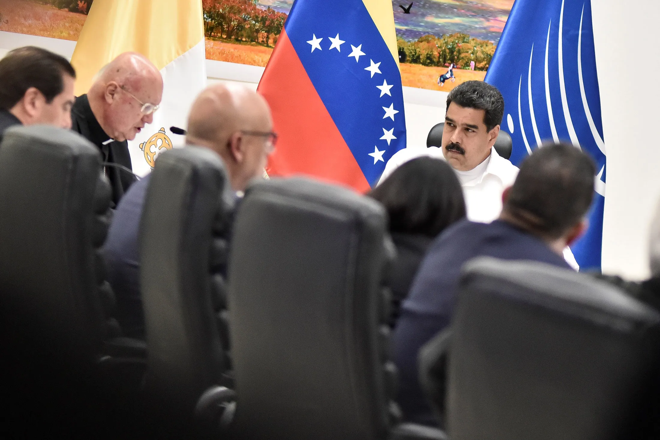 Venezuela's President Nicolas Maduro, right, looks at Vatican's pontifical council for social communications, Monsignor Claudio Maria Celli as he gives a speech at the meeting between Venezuela's government and opposition leaders for Vatican-backed talks, in a bid to defuse the country's political crisis, in Caracas on October 30, 2016.
