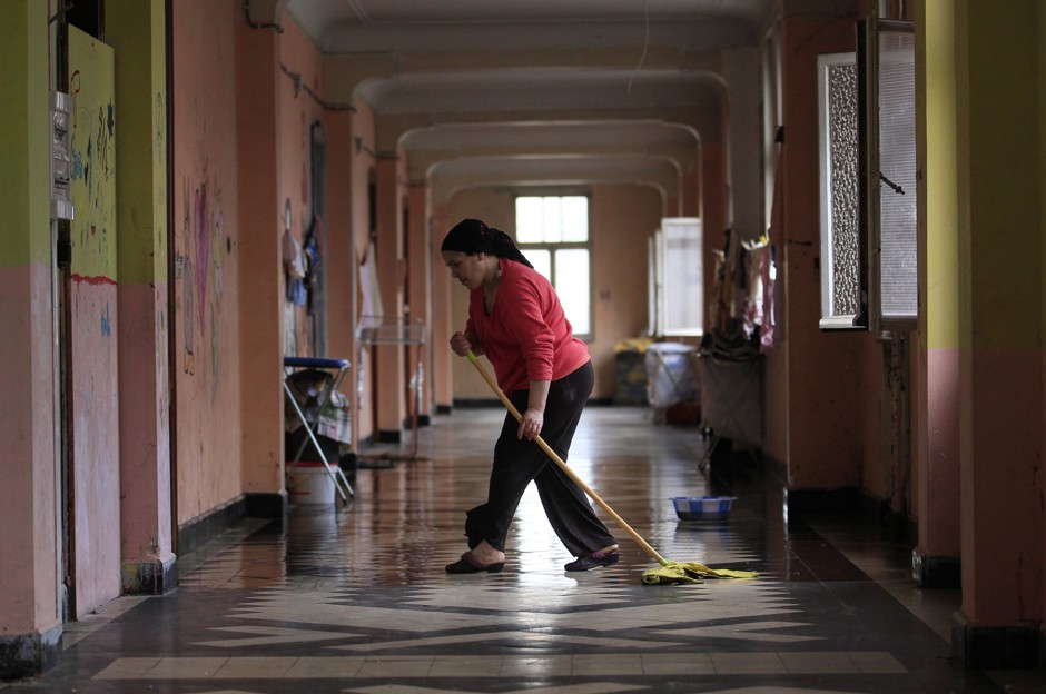 A woman cleans a corridor of an abandoned convent in Brussels.
