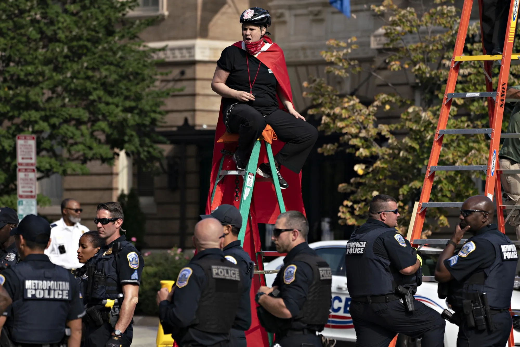 MPD officers stand near a protester chained to a ladder while blocking an intersection during the Shut Down DC climate demonstration in Washington in 2019.&nbsp;