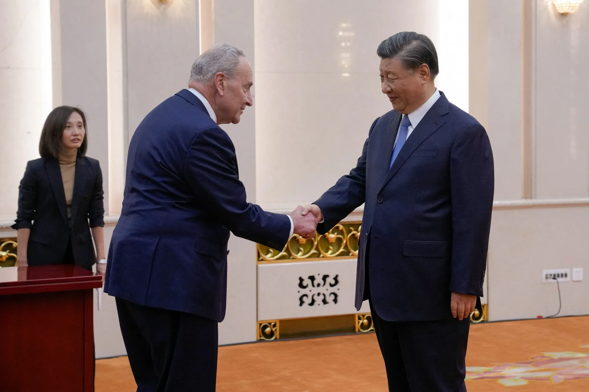 Chuck Schumer is greeted by Xi Jinping before their bilateral meeting, on Oct. 9.