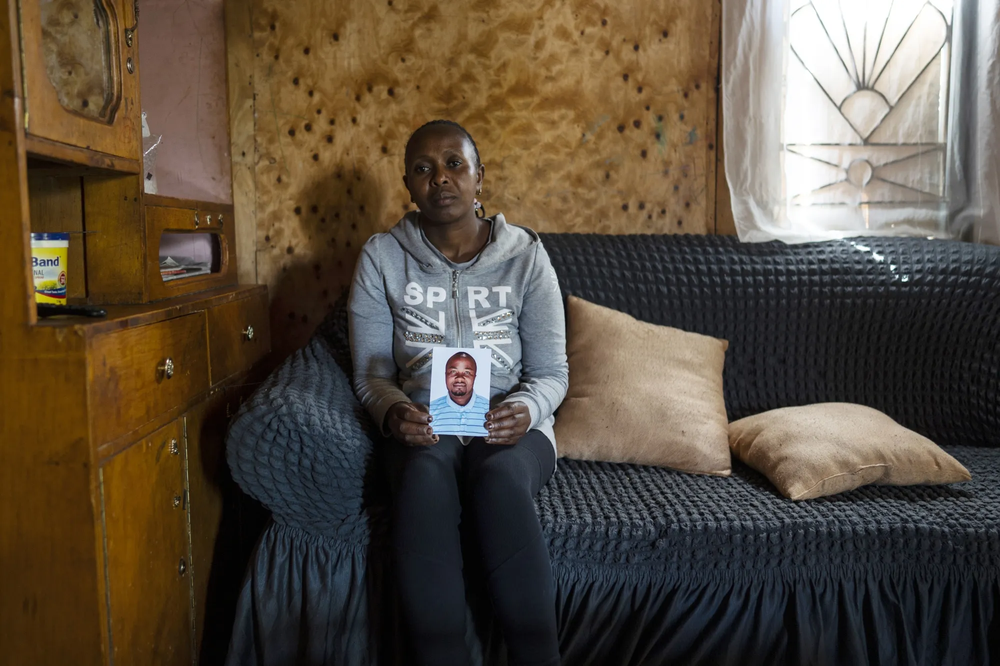 Grace Gathoni holds a picture of her husband, Martin Mburu, 38, at her home in Kenya’s Kiambu County, on Dec. 12. Mburu has been reported dead on the frontlines of Russia's war against Ukraine.