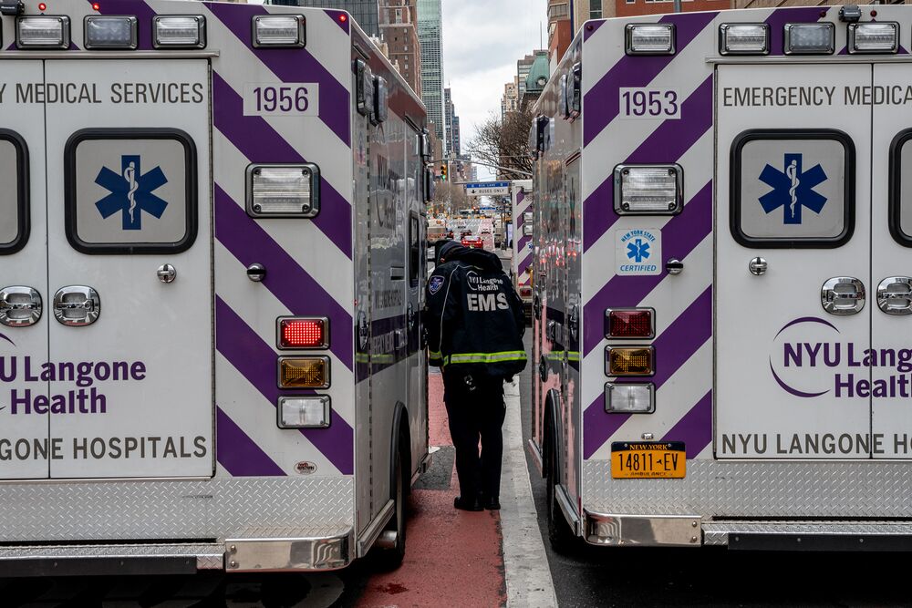 A EMS worker walks in between two ambulances parked out side of the emergency room at NYU Langone Heath in New Yok on April 10, 2020.