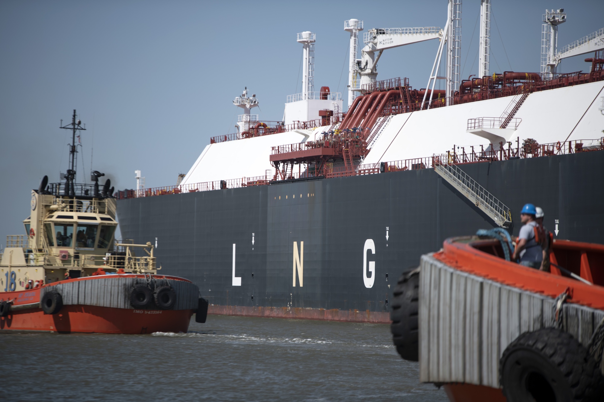 Tug boats prepare to pull out an LNG tanker at the Cheniere Sabine Pass Liquefaction facility in Cameron, Louisiana on April. 14, 2022.