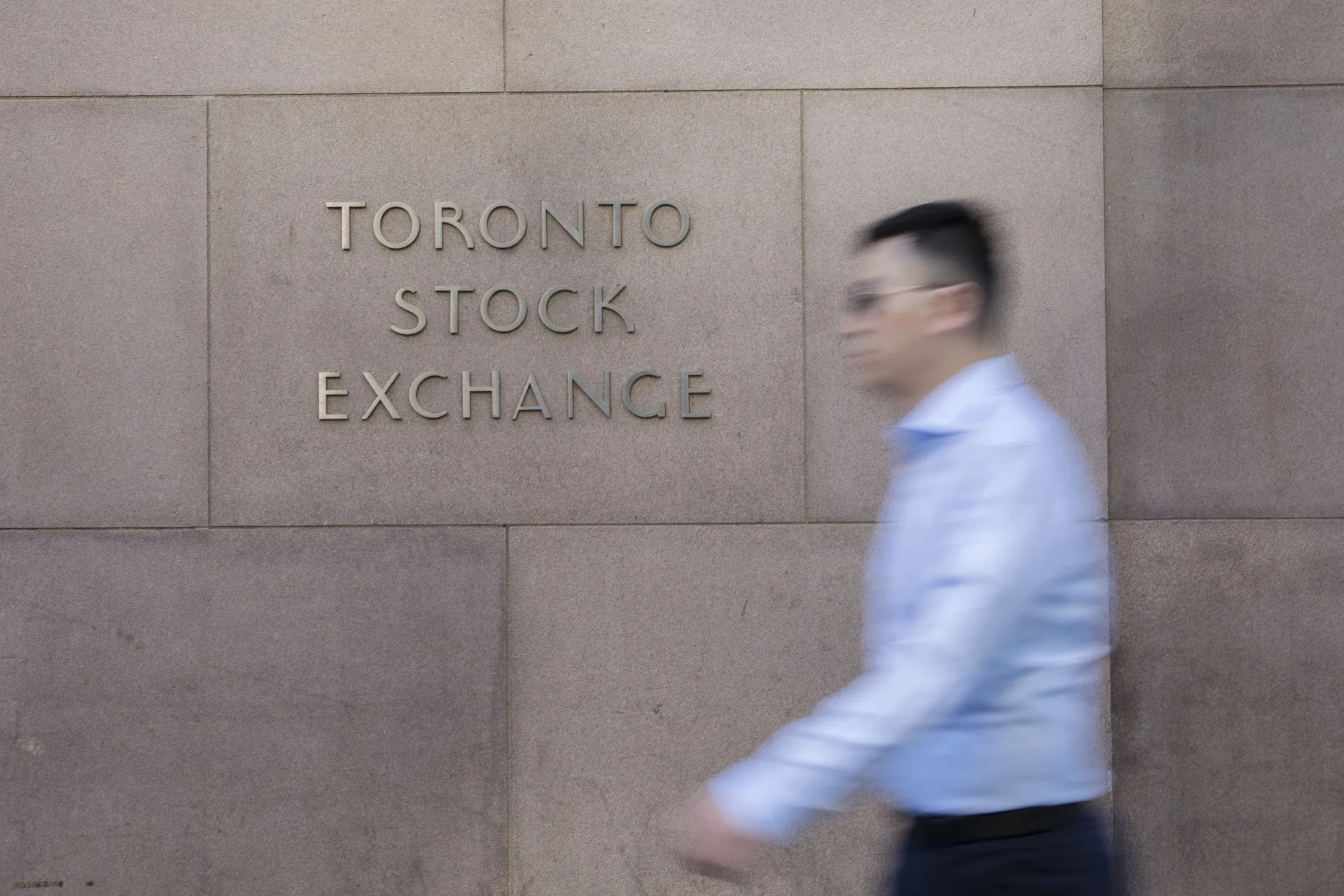 A pedestrian walks past the Toronto Stock Exchange.