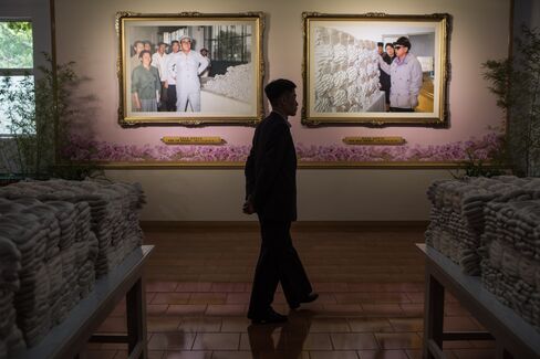 Portraits of Kim Il-Sung, left, and Kim Jong-Il at a silk factory.
