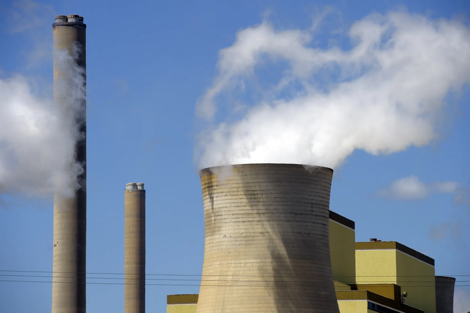Emissions billow from cooling towers.