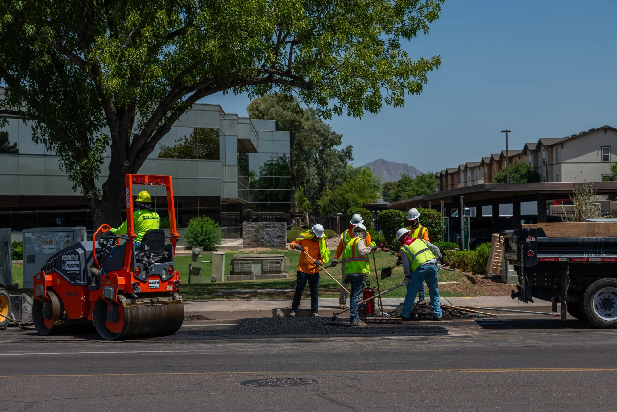 Construction workers pour asphalt for road repairs in Tempe, Arizona.