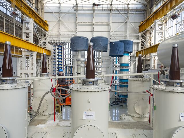 A technician working on a large power transformer in the high voltage testing area at the GE Vernova factory.