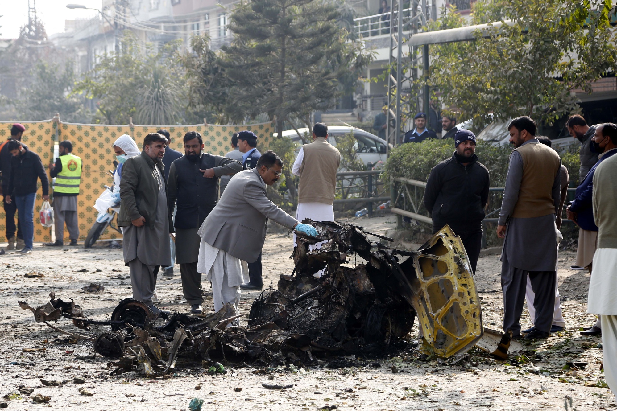 Security personnel investigate at the site of a suicide attack in Islamabad on Dec. 23