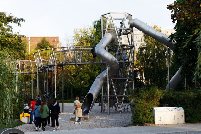 Adults wait at the bottom of a slide at Salyut Playground in Gorky Park in Moscow. 