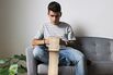 Teenage boy sitting on couch at home looking at cell phone