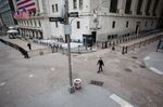 A pedestrian wearing a protective mask walks along Wall Street.