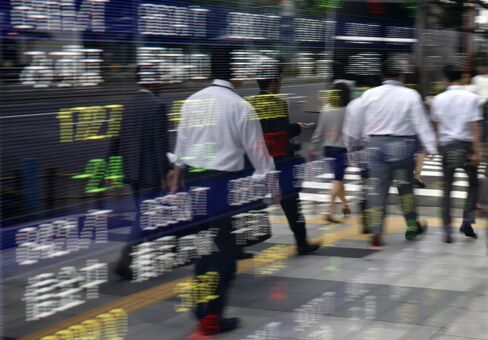 株価ボードと歩行者