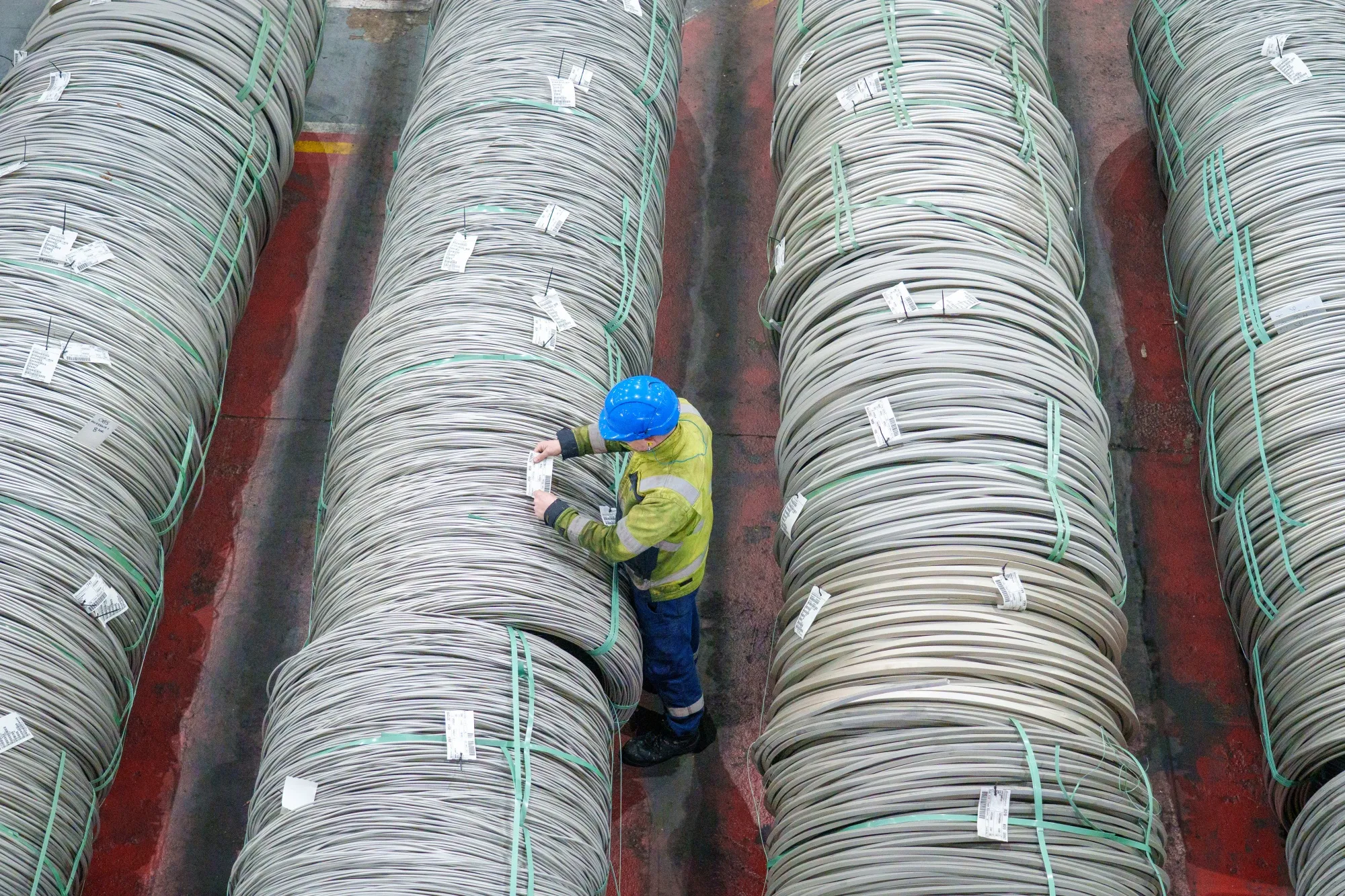 A worker checks stainless steel coils at a&nbsp;bar finishing facility in Sheffield, UK.
