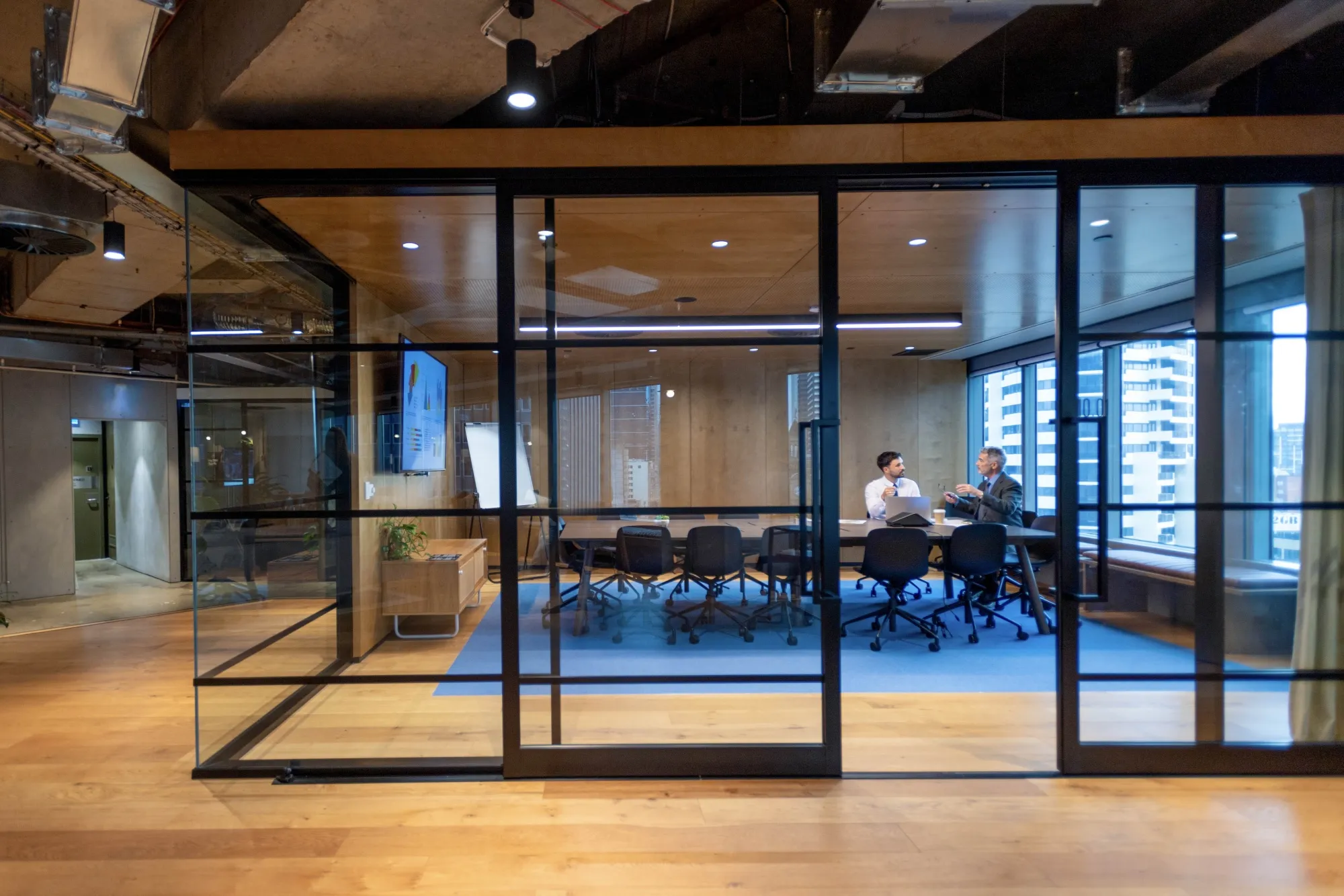 Business people working in a board room with a laptop and presentation.