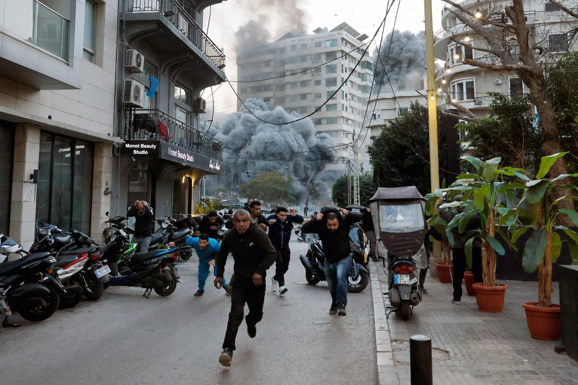 People escape an Israeli airstrike on a building in Beirut's Bashura neighborhood&nbsp;on March 12.&nbsp;