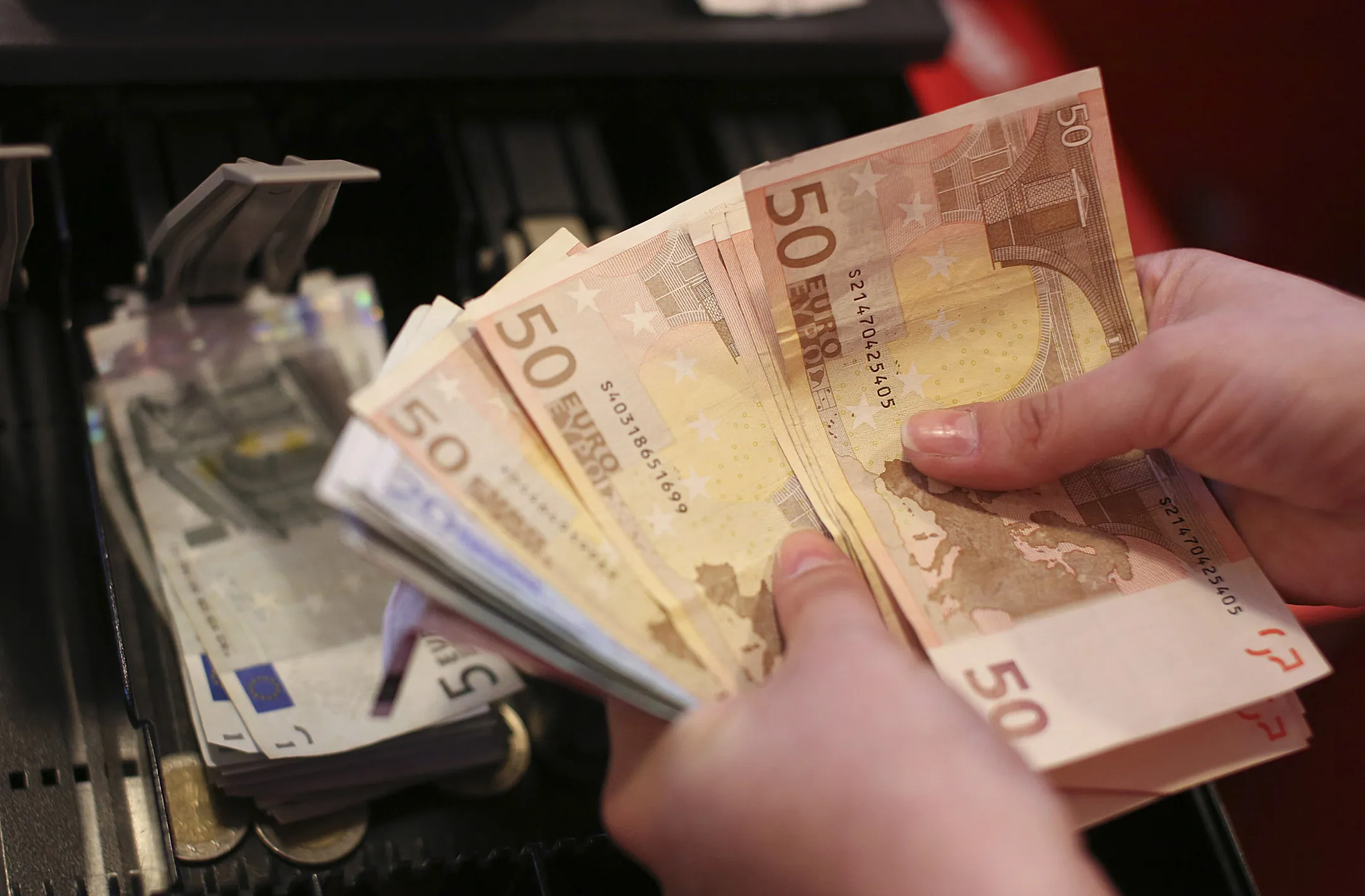 An employee counts fifty and twenty euro notes at the cash desk inside a Mercator Poslovni Sistem d.d. supermarket in Ljubljana, Slovenia, on Wednesday, May 8, 2013. In January Mercator reported its first full-year loss in fifteen years as the largest supermarket chain's sales in the Balkans last year suffered during the recession.