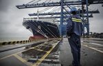 A dock worker looks at a container ship&nbsp;in Guangzhou, China.