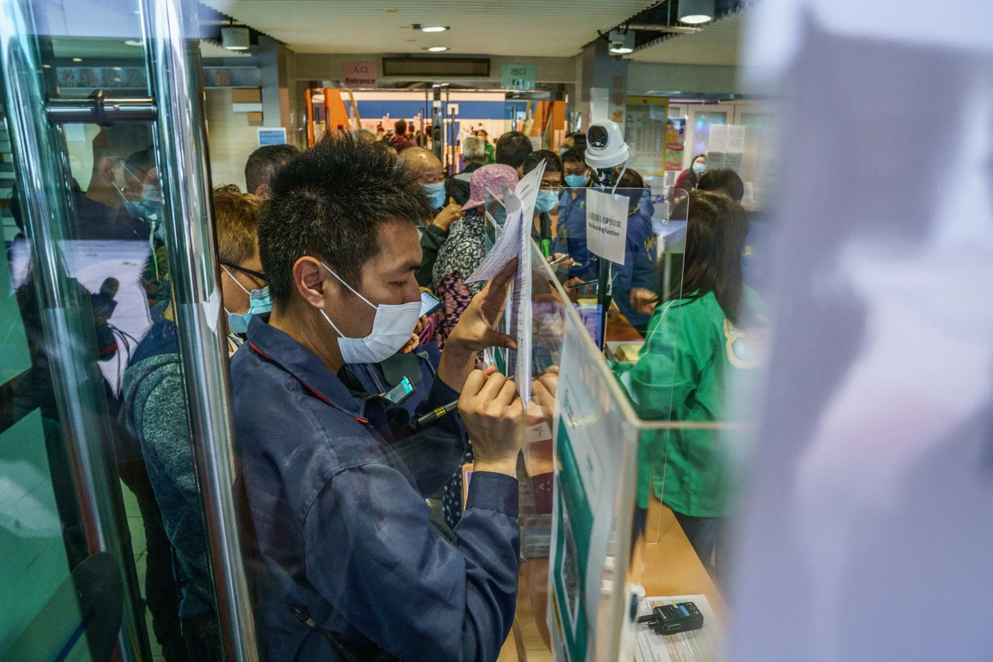 People fill in their personal details before entering a community vaccination center&nbsp;in Hong Kong on March 10.