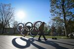 A pedestrian walks past the Olympics rings in Tokyo, Japan.