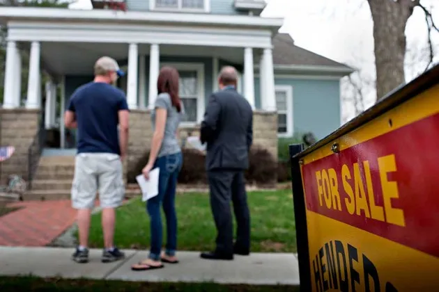 Potential home buyers outside a previously owned home in Mackinaw, Ill., on April 21