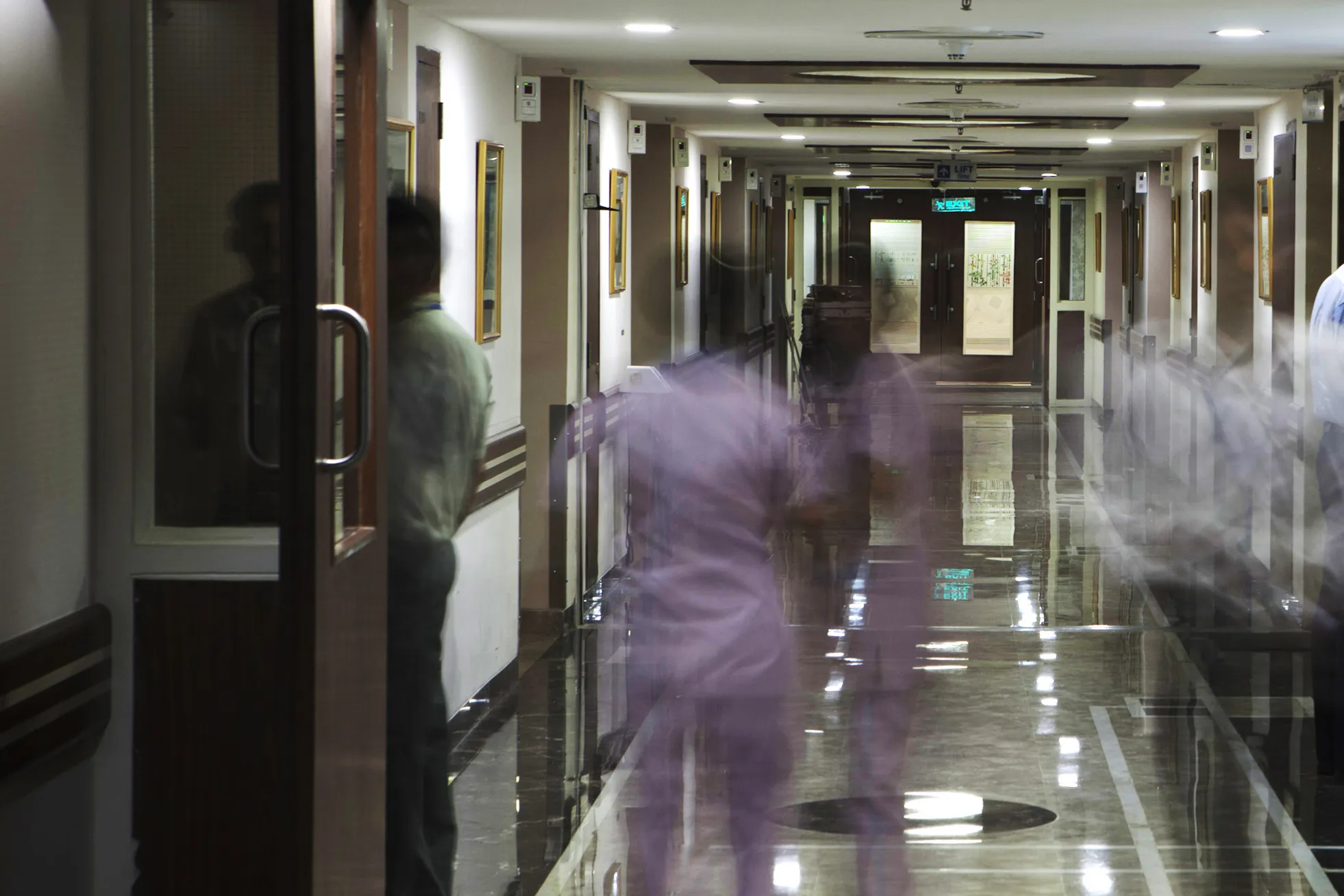 People move through the corridor of a patient ward at the Indraprastha Apollo Hospitals facility.
