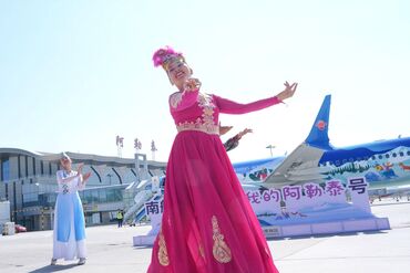 Altay, China's Xinjiang Uygur Autonomous Region. 24th June, 2026. A performance is staged during the launching ceremony of a painted plane at an airport in Altay, northwest China's Xinjiang Uygur Autonomous Region, June 24, 2026. China Southern Airlines h