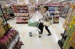 A customer pushes a shopping cart at an Aeon Co. supermarket during a sale jointly held with Daiei Inc. in Tokyo, Japan, on Thursday, Aug. 22, 2013. Aeon's acquisition of 48.4 million Daiei shares will take place on Aug. 27 after the completion of tender offer yesterday, according to a statement to the Tokyo Stock Exchange released today.