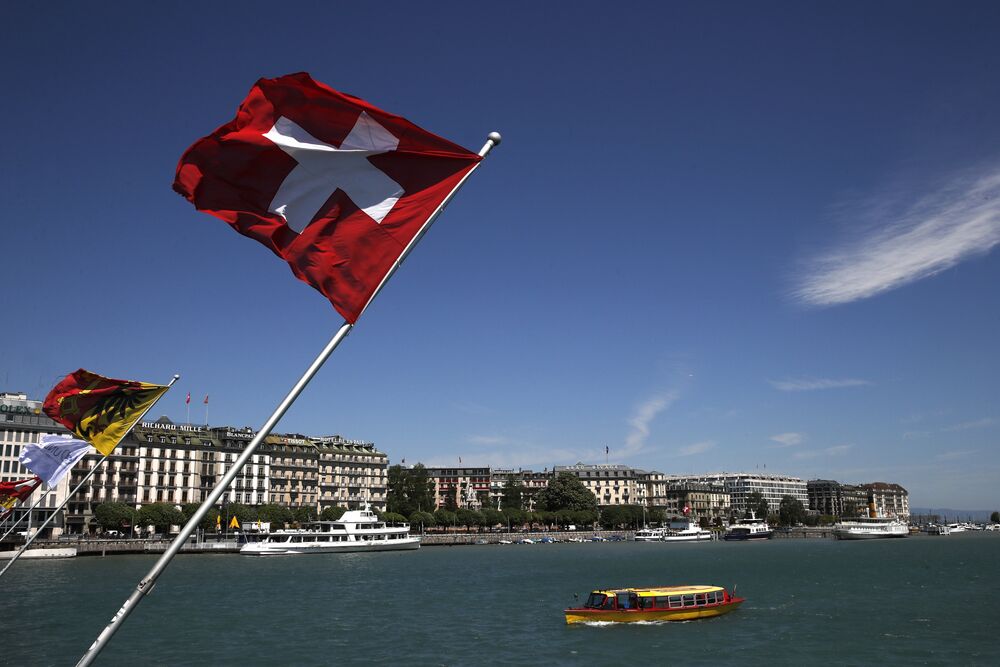 A Swiss national flag flies from the shores of Lake Geneva.