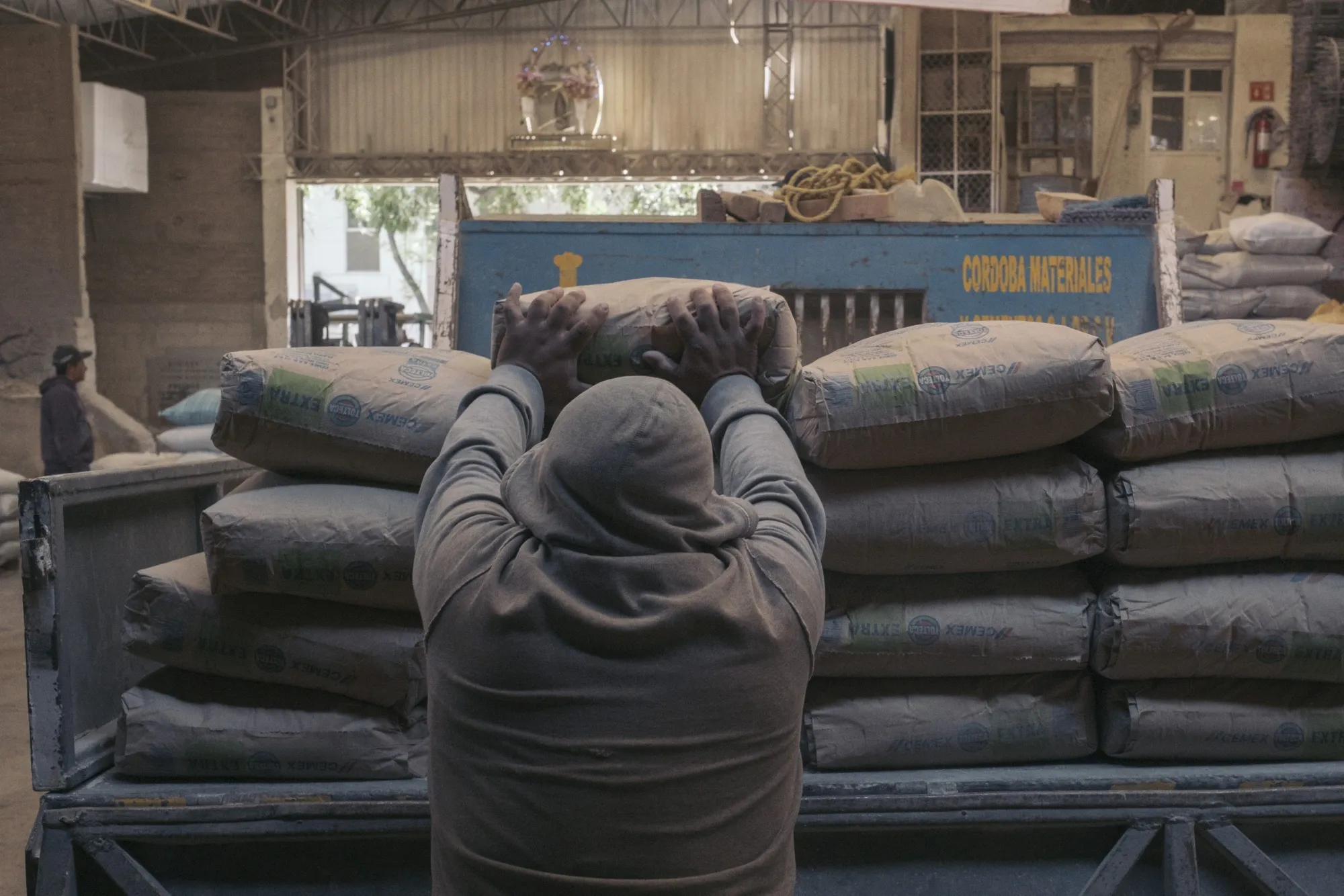 A worker stacks Cemex cement bags at a wholesale warehouse in Mexico City.&nbsp;