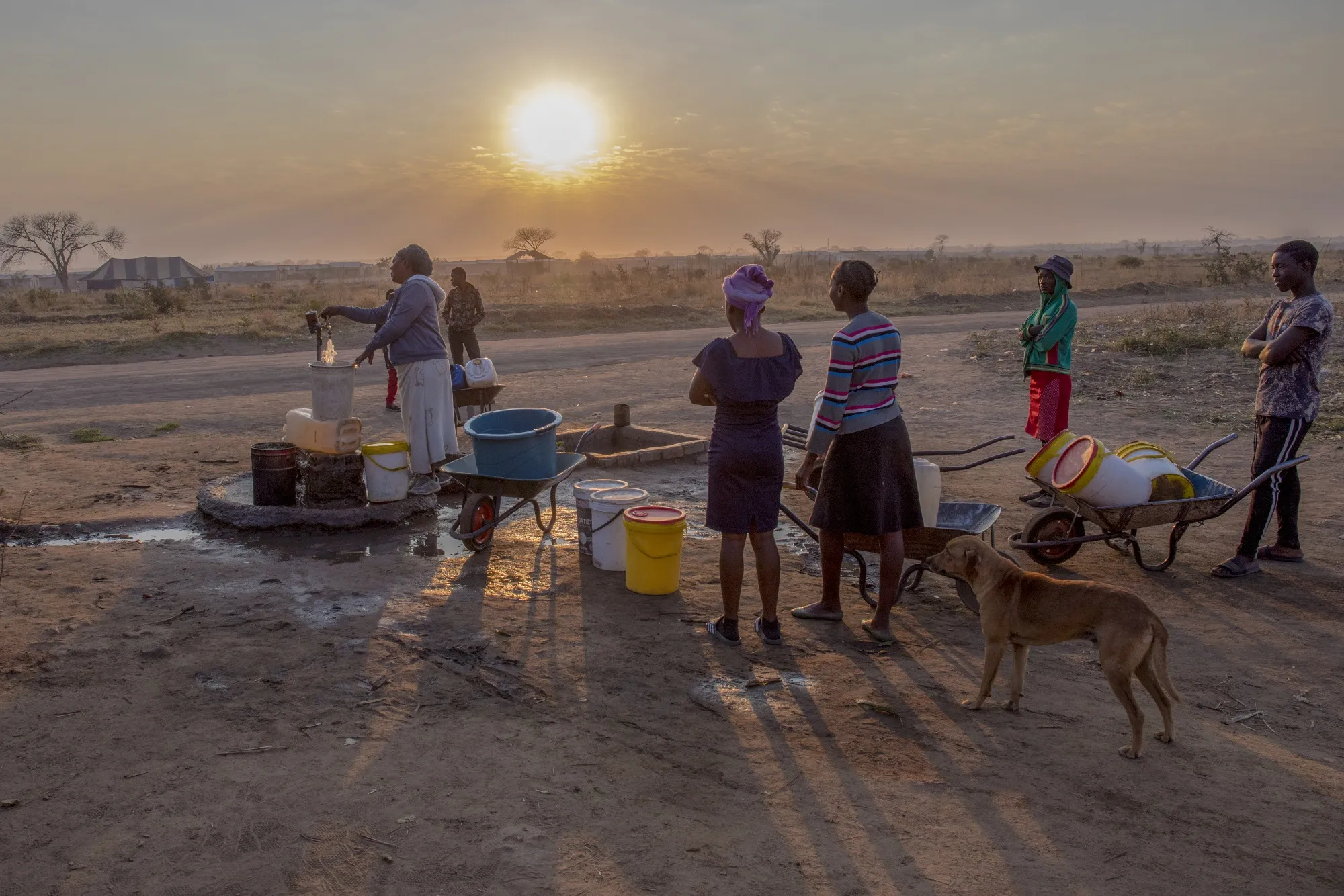 Local residents queue to fill buckets and containers with water at a communal tap in Empompini in Cowdray Park, Bulawayo, Aug. 3, 2019.