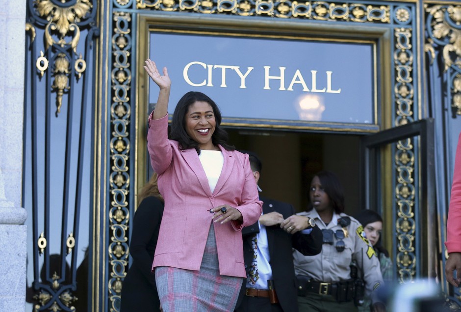 London Breed waves before speaking to reporters outside of City Hall in San Francisco.