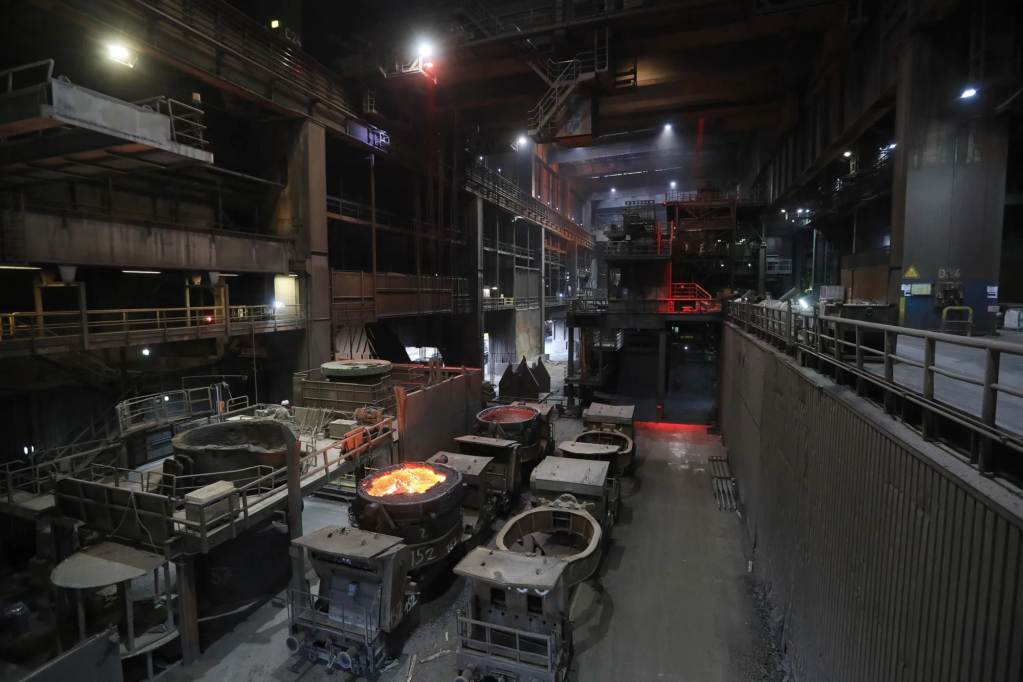 Vats of molten metal sit in the oxygen converter hall at a metals plant in Germany.