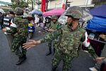 Thai soldiers inspecting the site of a bomb blast near an anti-government rally in Bangkok