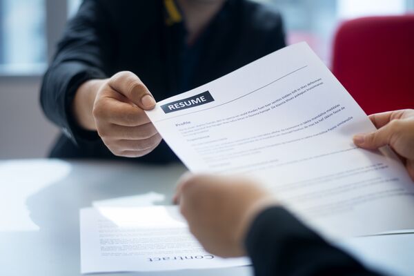 Recruitment, Job application, contract and business employment concept. Hand giving the resume to the recruiter to review the profile of the applicant.