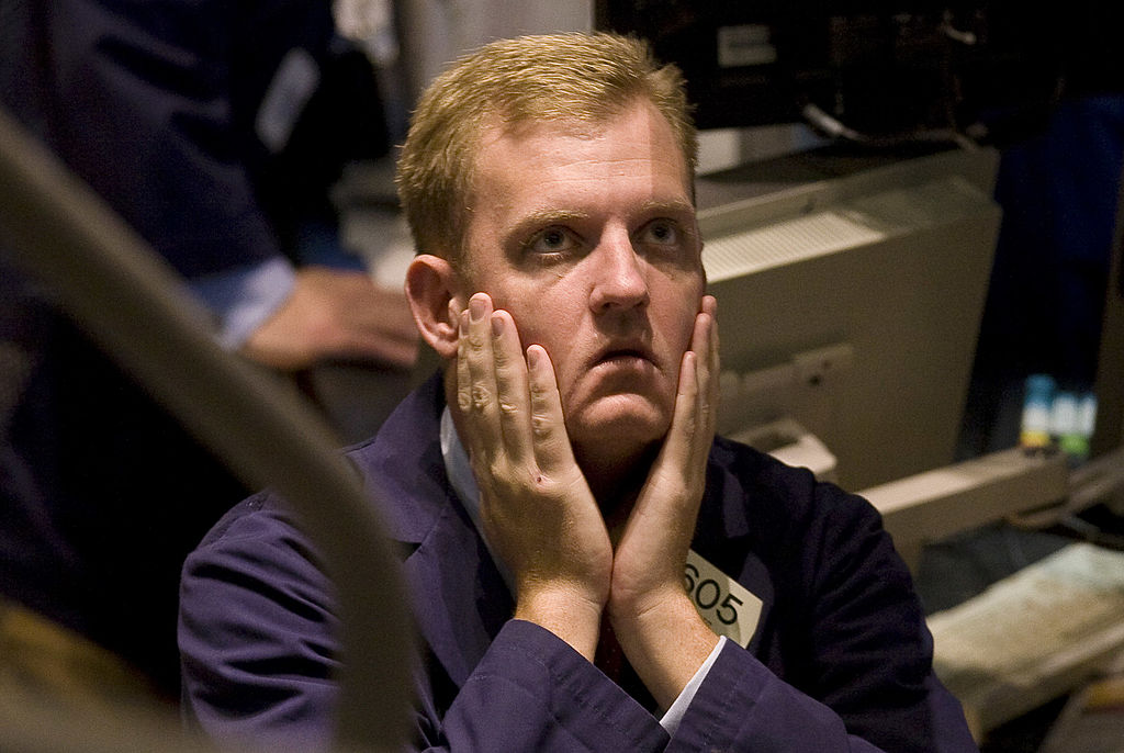 UNITED STATES - OCTOBER 03: A trader rubs his face on the floor of the New York Stock Exchange in New York, U.S., on Friday, Oct. 3, 2008. U.S. stocks slid, capping the worst week for the Standard & Poor's 500 Index since the 2001 terrorist attacks, on concern the $700 billion bank bailout isn't enough to unlock credit markets and prevent a recession. (Photo by Jeremy Bales/Bloomberg via Getty Images)