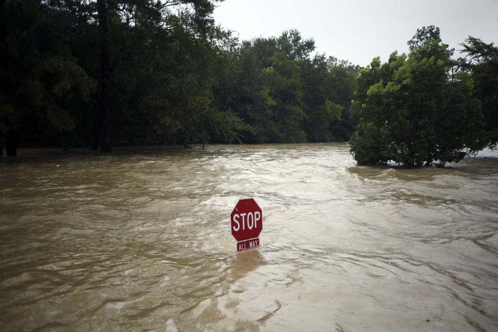 A &quot;Stop&quot; sign stands in floodwaters due to Hurricane Harvey in Spring, Texas, U.S., on Monday, Aug. 28, 2017. A deluge of rain and rising floodwaters left Houston immersed and helpless, crippling a global center of the oil industry and testing the economic resiliency of a state that's home to almost 1 in 12 U.S. workers.
