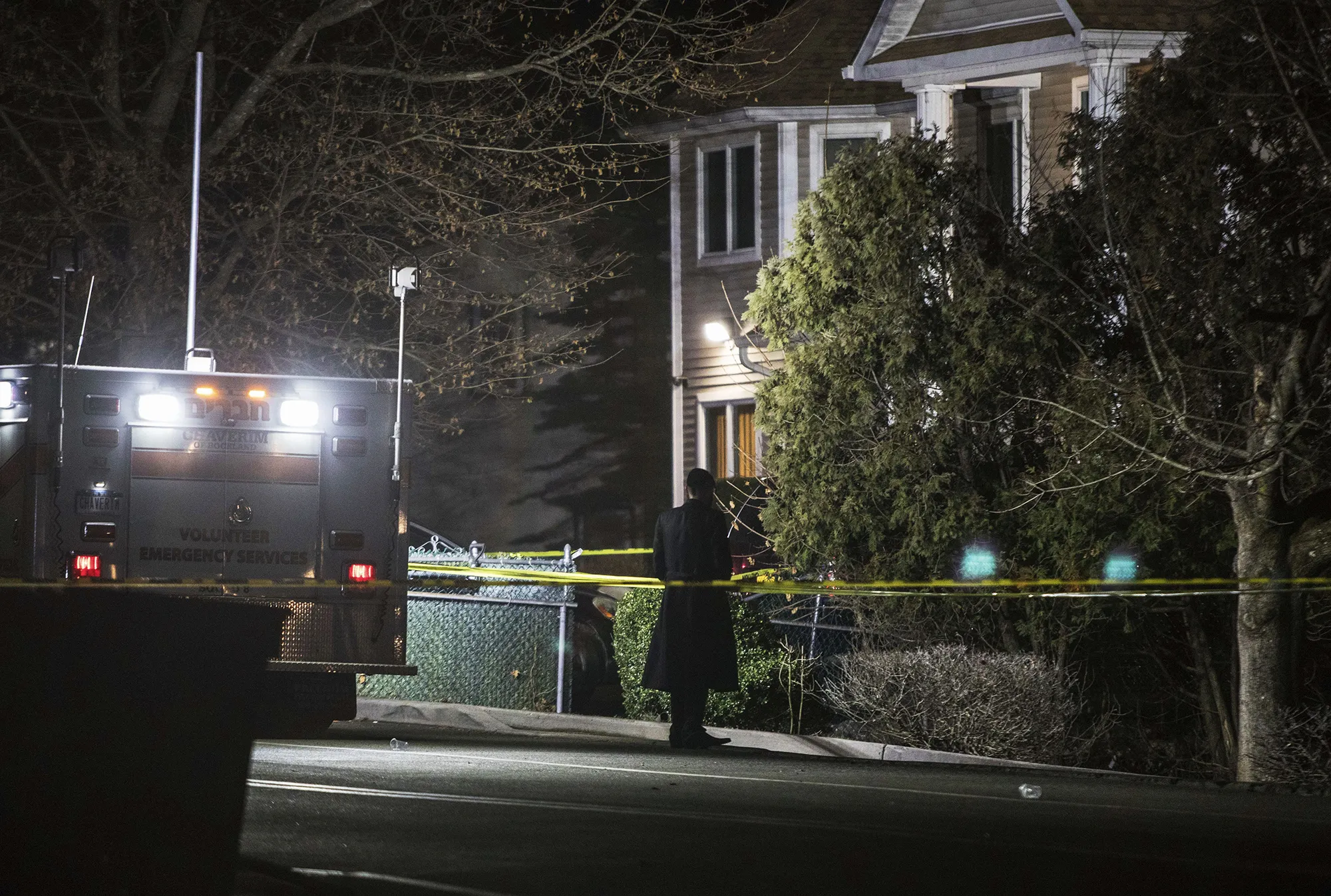 An Orthodox Jewish man stands in front of a residence in Monsey, N.Y., Sunday, Dec. 29, 2019, following a stabbing late Saturday during a Hanukkah celebration. A man attacked the celebration at the rabbi's home north of New York City late Saturday, stabbing and wounding several people before fleeing in a vehicle, police said. (AP Photo/Allyse Pulliam)