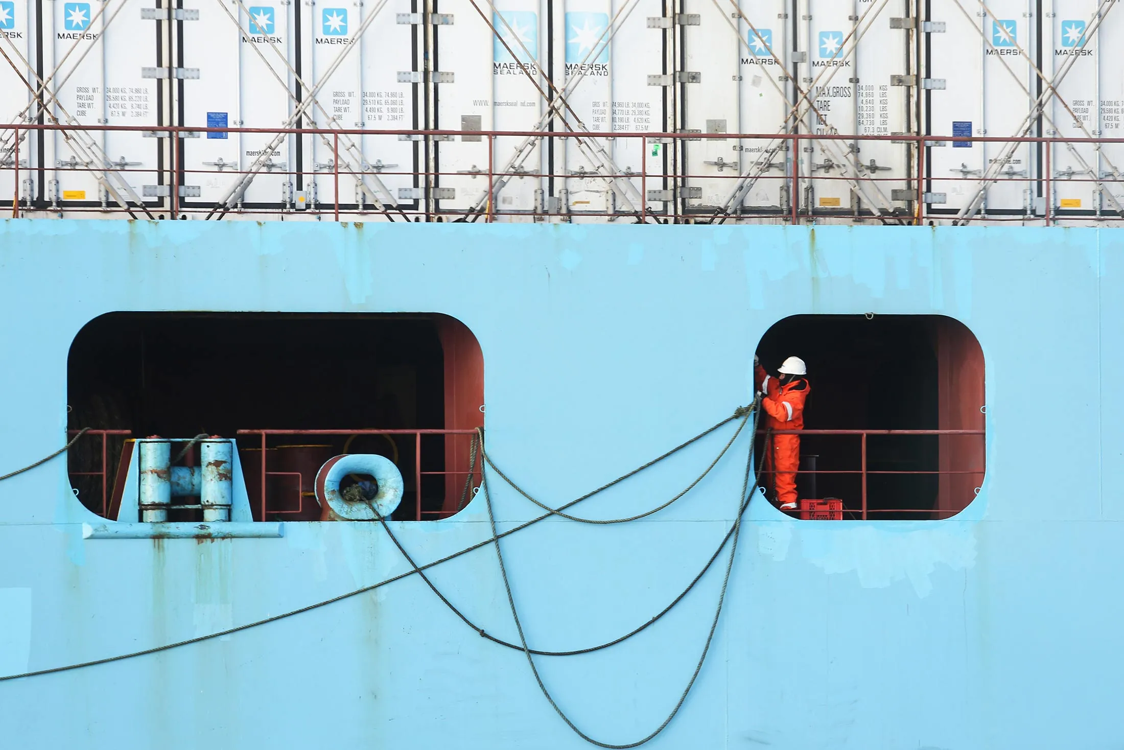 An employee prepares to throw ropes to the dockside from onboard the Luna Maersk container ship, operated by A.P. Moeller-Maersk A/S, at the Port of Felixstowe Ltd., a subsidiary of CK Hutchison Holdings Ltd., in Felixstowe, U.K., on Tuesday, Feb. 2, 2016. A vote to leave the EU could force the Bank of England to keep interest rates at a record low for an 'extended period of time' or even lower them to shore up the economy as Britain ends its 43-year membership in a 500 million-person bloc that buys almost half its exports.
