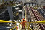 A worker walks down a set of stairs on an oil drilling rig operated by Pemex off the coast of Ciudad del Carmen, Mexico.