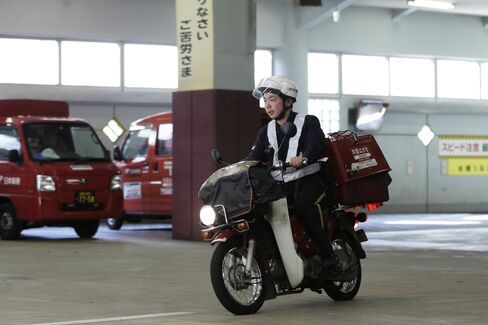 A mail carrier departs from a Japan Post post office