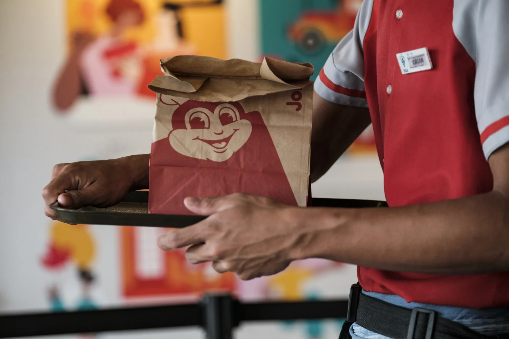 A service assistant carries a takeaway order at a Jollibee restaurant in Quezon City, Metro Manila, the Philippines.