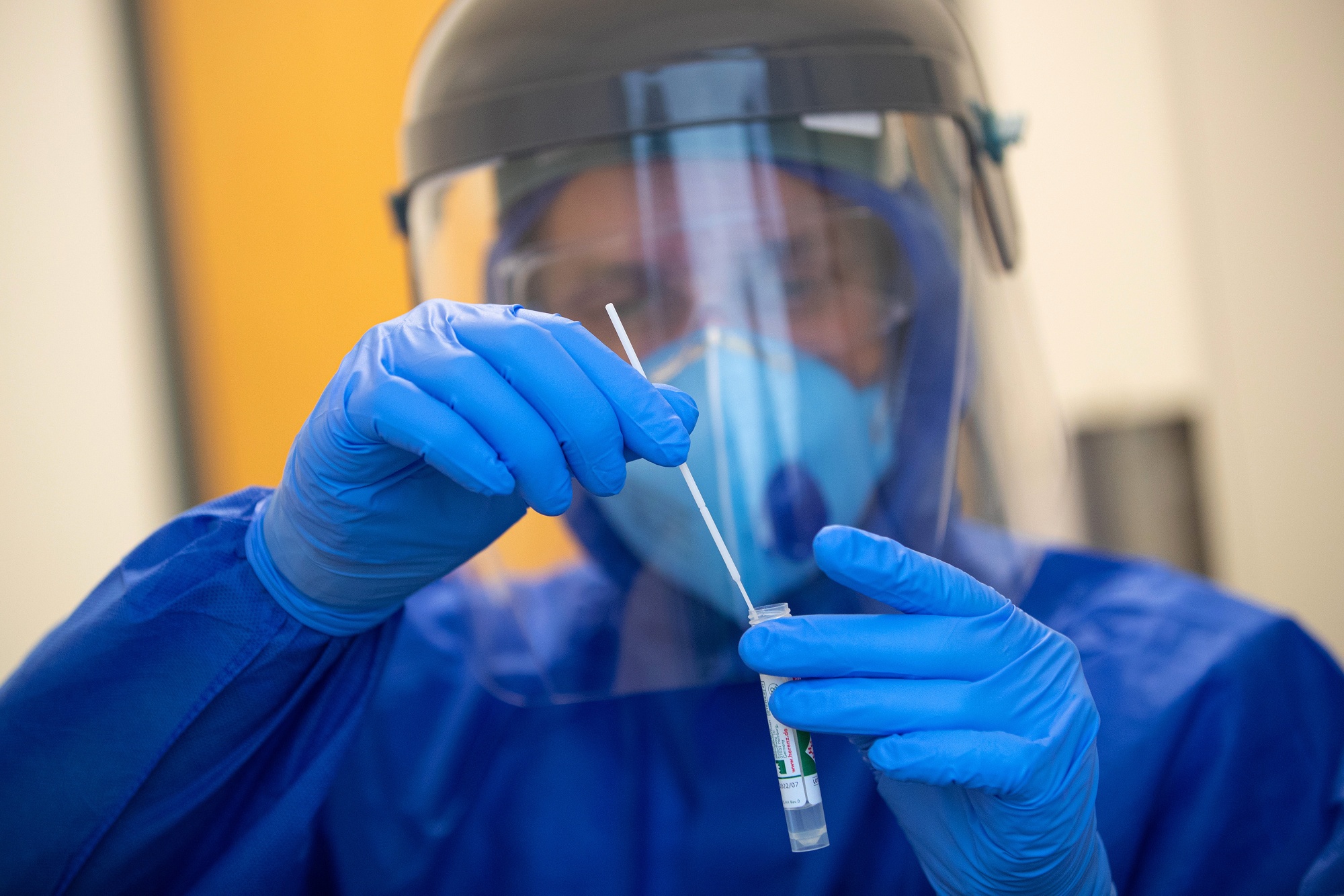 An employee holds a polymerase chain reaction (PCR) swab test kit at a Covid-19 testing shipping container in Wolfsburg, Germany, on&nbsp;Aug. 25.
