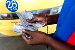 A taxi driver counts a bundle of Kenyan shilling notes in Mombasa, Kenya